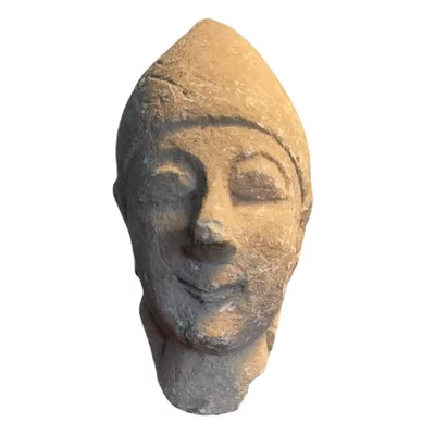 Cypriot head of a male votary. Archaic Cyprus. Beardless male wearing a conical helmet. Main view of the sculpture